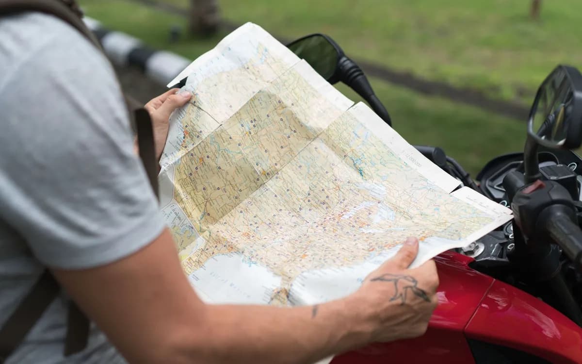 Pessoa examina um mapa de cidade na rua, ilustrando a procura de um endereço.